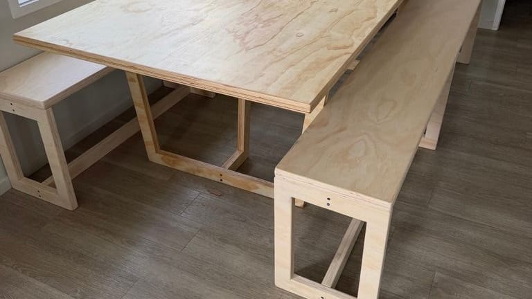 Finished ply table with two matching benches in a bright dining nook